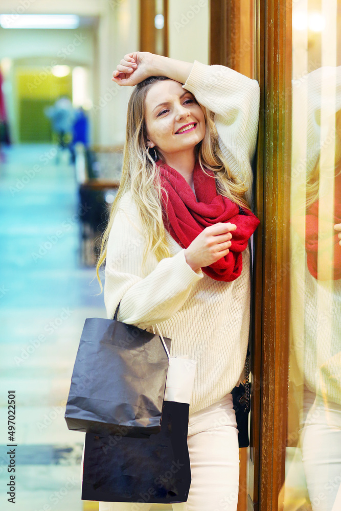 happy blond girl in red scarf hold shopping bag with copy space close up photo