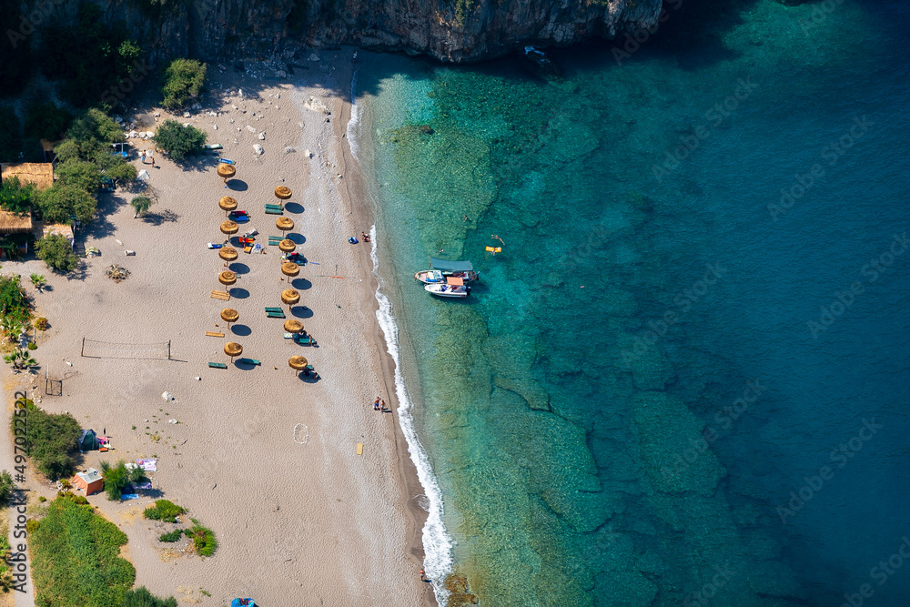 Amazing aerial view of Butterfly Valley in Fethiye Turkey. Summer landscape with mountains, green forest, azure water, sandy beach and blue sky in bright sunny day. Travel background. Top view. Nature