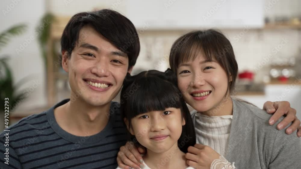 headshot portrait of beautiful asian family of three embracing each other and looking at camera with smile at home. headshot portrait of beautiful asian family of three embracing each other and looking at camera with smile at home.