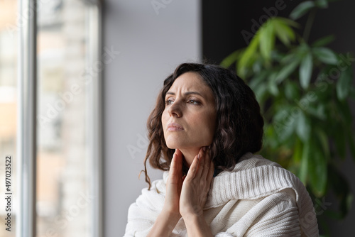 Canvas Print Young sick unhealthy woman covered in knitted plaid suffering from sore throat and swollen glands, feeling discomfort and pain when swallowing