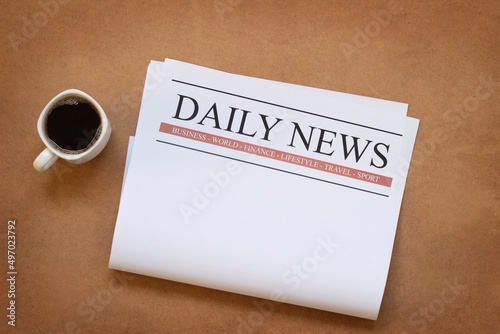 Blank daily newspaper and coffee cup on wooden table. News mock up concept