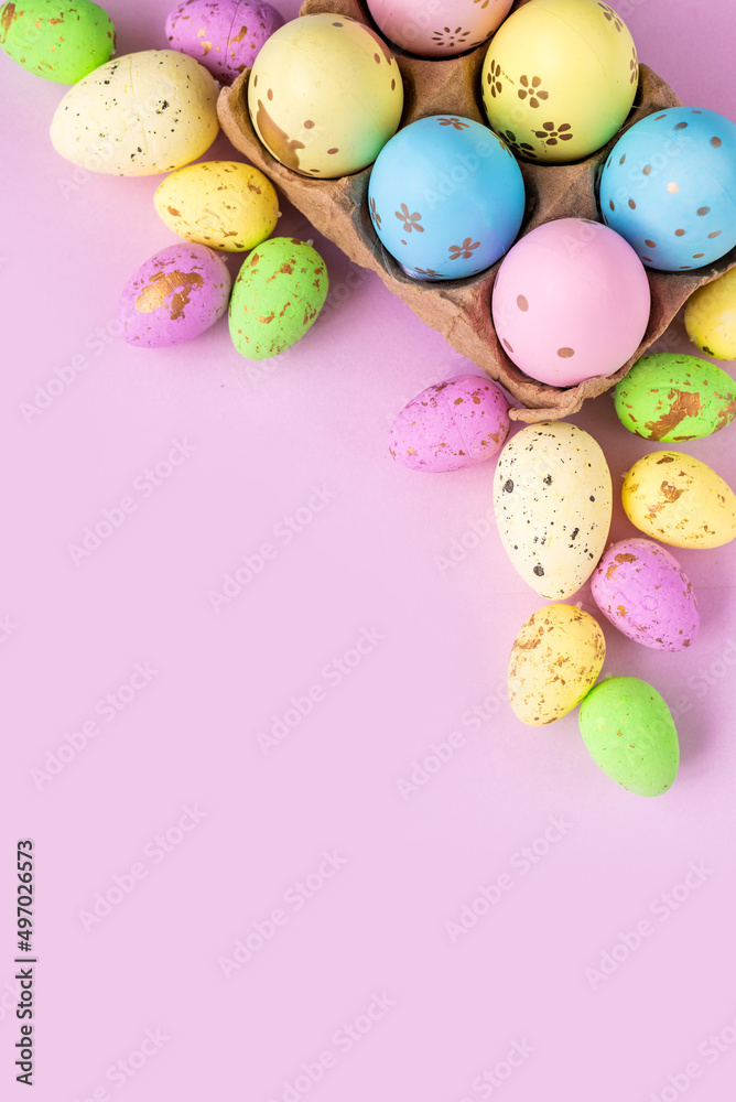 Painted eggs of different colors on a lilac background. Design for Easter greetings with space for text