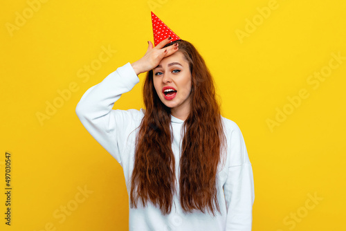 Yikes, oops. Bothered and embarrassed girl slap forehead and roll eyes displeased, remember something, standing upset against yellow background photo