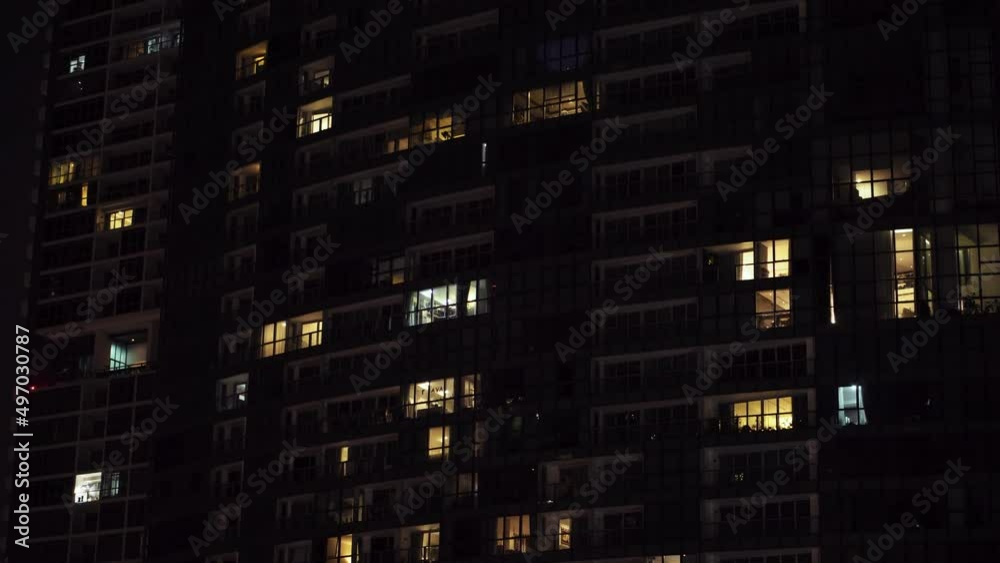 Beautiful windows of skyscrapers view of modern residential high-rise buildings, people moving inside apartments. aerial view below pan up Beautiful windows of skyscrapers view of modern residential high-rise buildings, people moving inside apartments. aerial view below pan up