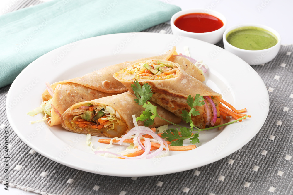 Indian Frankie Veg chapati Wrap / Kathi Roll, served in a plate with sauce & mint chutney. selective focus Indian Frankie Veg chapati Wrap / Kathi Roll, served in a plate with sauce & mint chutney. selective focus