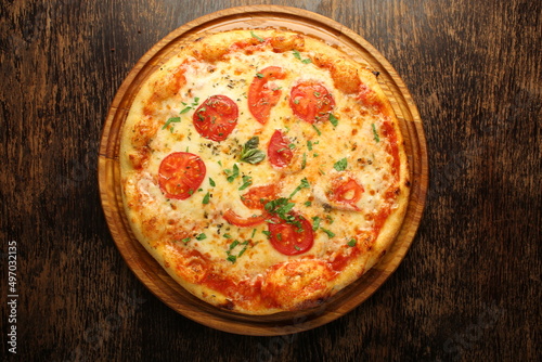 Pizza with tomatos, cheese and ham on a dark background. Italian pizza
