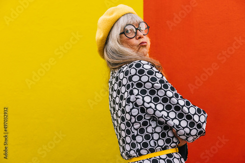 Photography Funny elderly woman pouting her lips against a colourful background