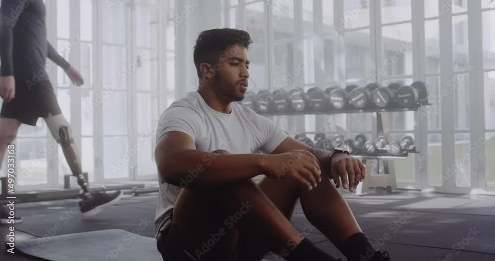Biracial male in modern style gym checking timer on his watch and doing sit ups exercise. Biracial male in modern style gym checking timer on his watch and doing sit ups exercise.