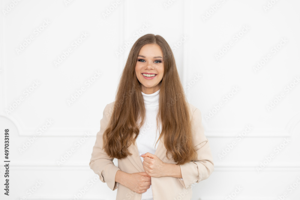 Uśmiechnięta kobieta w beżowej marynarce - białe zęby po zdjęciu aparatu ortodontycznego - obrazy, fototapety, plakaty 