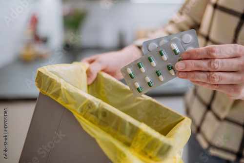 Canvas Print Woman's hands holding and throwing expired pills to the trash bin