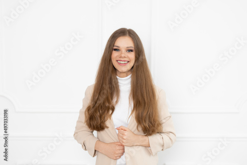 Uśmiechnięta kobieta w beżowej marynarce - białe zęby po zdjęciu aparatu ortodontycznego