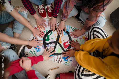 Obraz na plátne Top view of students making a poster of peace sign at school.