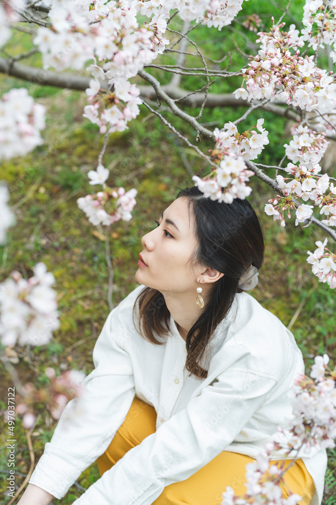 満開の桜の花と爽やかな女性