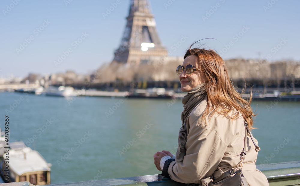Attractive young romantic woman enjoy beautiful view of Paris and Eiffel Tower.Travel tourist girl on vacation in France.