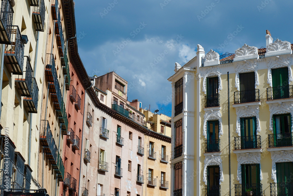 Classical buildings with balconies and windows with elegant ornate in downtown district of Madrid, Spain. Vivid colours, old-fashioned ornamental details