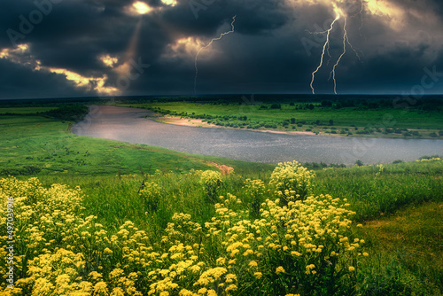 summer thunderstorm over the lightning river top view yellow meadow of flowers on the hill