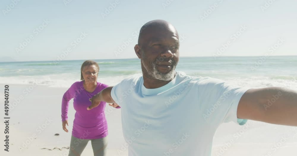 Smiling senior african american couple practicing yoga on sunny beach Smiling senior african american couple practicing yoga on sunny beach