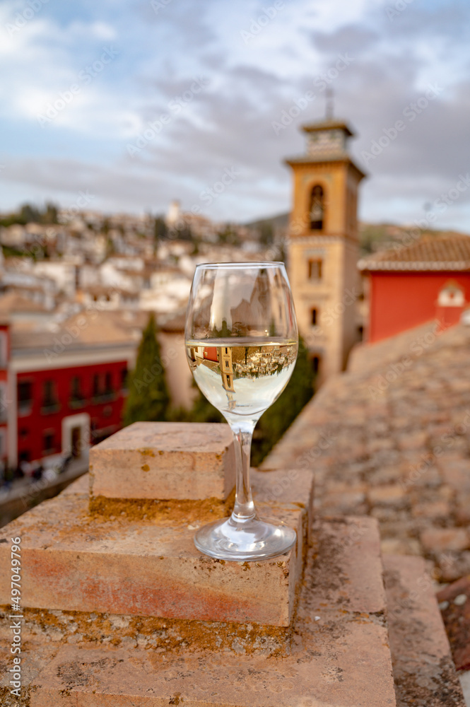 Glass of Spanish dry rueda white wine served on roof terrace with view on old part of Andalusian town Granada, Spain Glass of Spanish dry rueda white wine served on roof terrace with view on old part of Andalusian town Granada, Spain