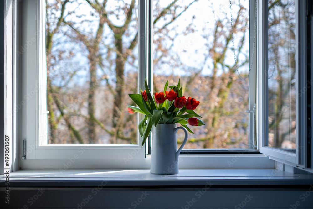 tulips in a vase in front of a window with a tree in the background tulips in a vase in front of a window with a tree in the background