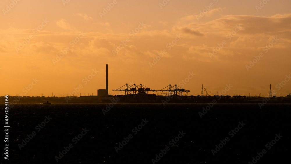 Silhouette of crane on the coast at sunset time.