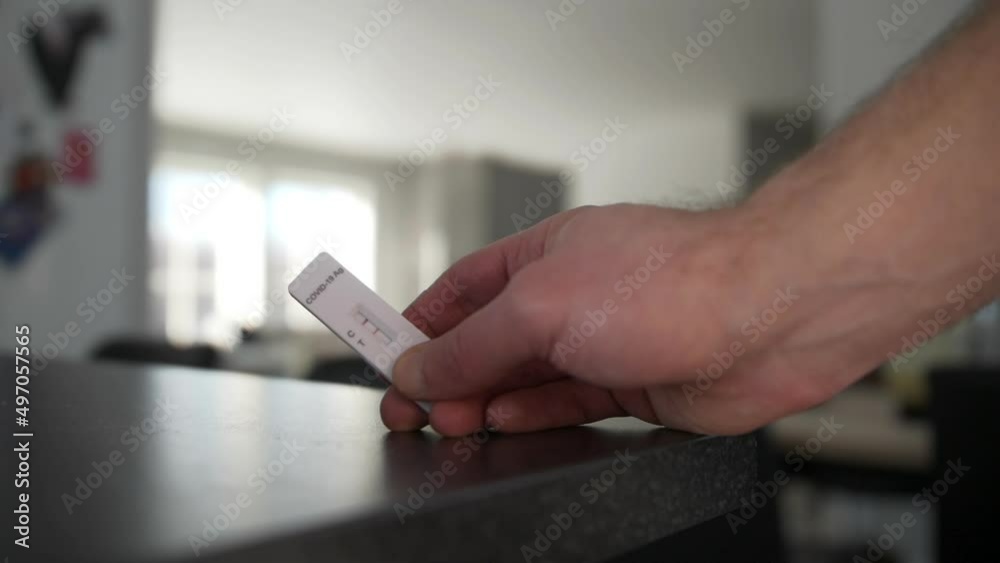 custom made wallpaper toronto digitalcloseup of hand holding a covid test in the living room showing positive