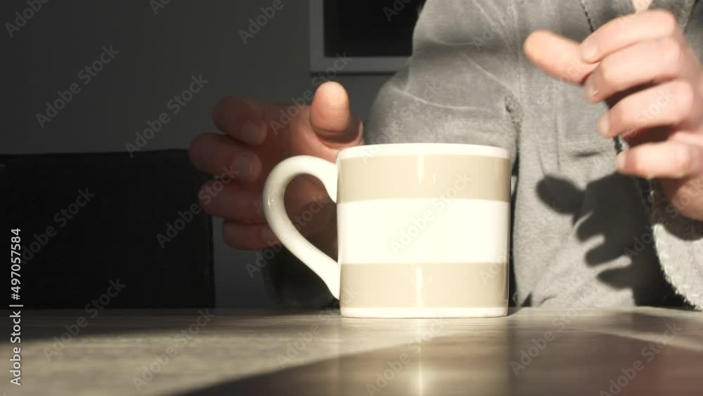 man wearing bathroom pulls chair to sit at table and drink morning coffee man wearing bathroom pulls chair to sit at table and drink morning coffee