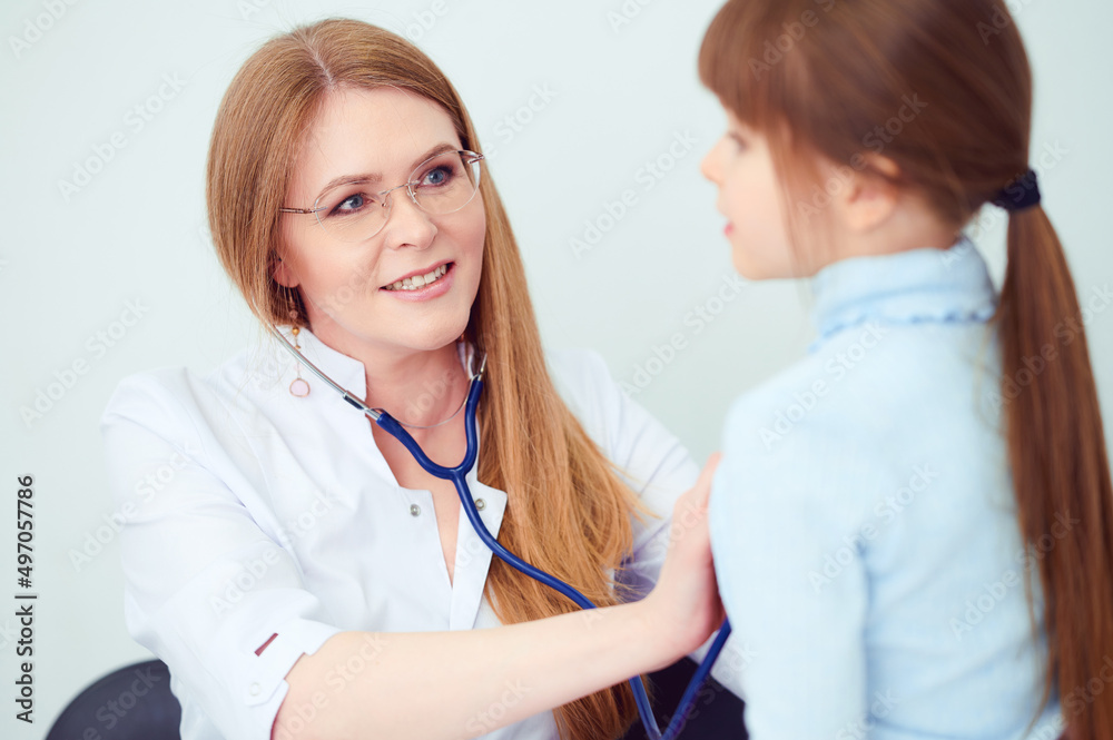 Cheerful female doctor checking patient little girl by stethoscope in hospital Cheerful female doctor checking patient little girl by stethoscope in hospital