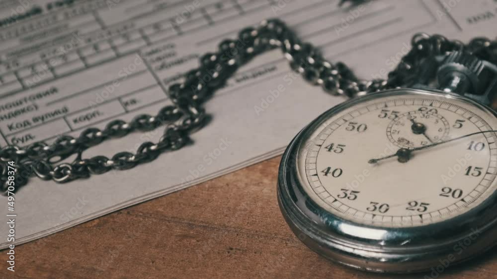 Vidéo Stock An antique stopwatch lies on wooden writing desk with retro