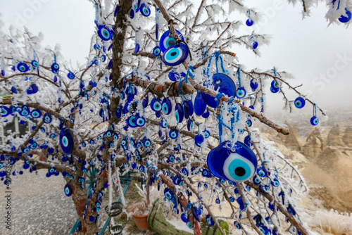 Blue evil eye ;nazar boncugu, turkish symbols hanging on a tree. cappadocia