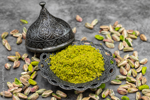Pistachio powder on dark background. It's surrounded by pistachios. close-up. local name toz antep fistik photo