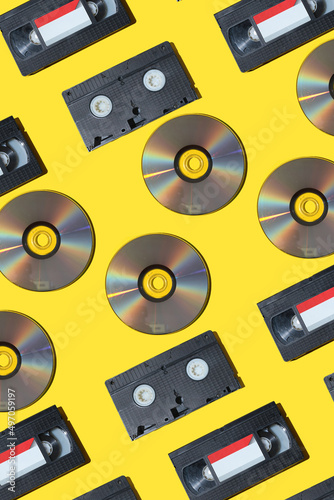 pattern with a VHS video cassette  Golden compact disc  Outdated technology background.