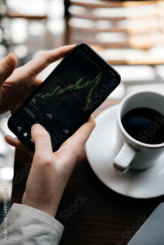 The girl analyzes the stock exchange, studying finance and economics over a cup of coffee, financial literacy and trading in the modern world