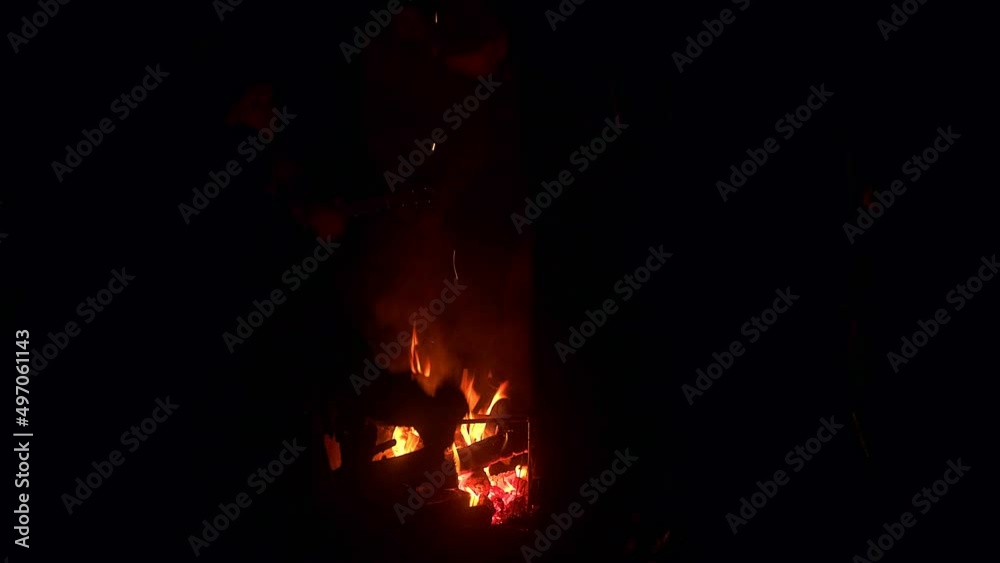 People sit around the campfire at night. Tourists rest at a rest stop, tell stories and sing songs People sit around the campfire at night. Tourists rest at a rest stop, tell stories and sing songs