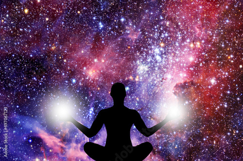 silhouette of a figure in yoga Lotus position with lights on each hand