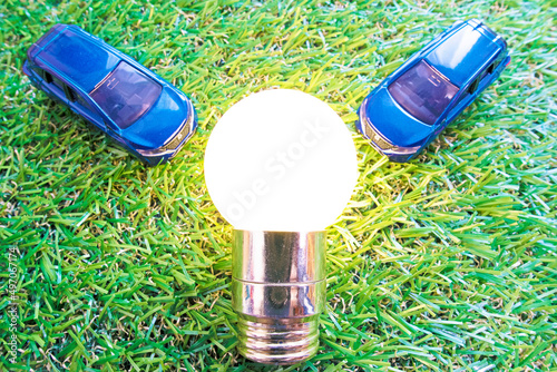 grass and light bulb and 2 cars