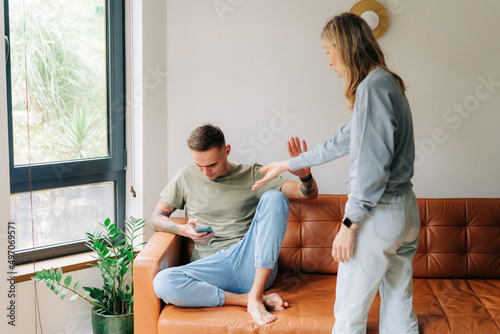 A woman quarrels with her husband about using a mobile phone and ignoring problems. photo