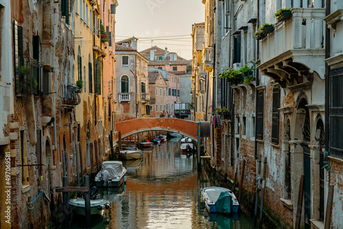 Venice, Italy - July 28 2021: Narrow canals with boats and gondolas in Venice, Italy