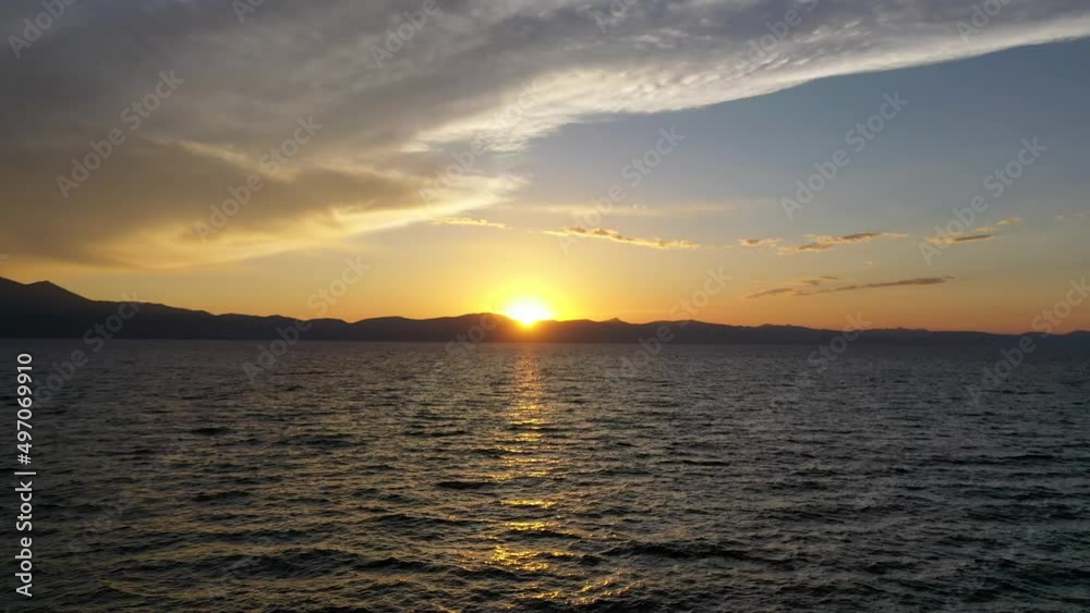 Flying Over Calm Ocean With Beautiful Sunset In The Background. - aerial