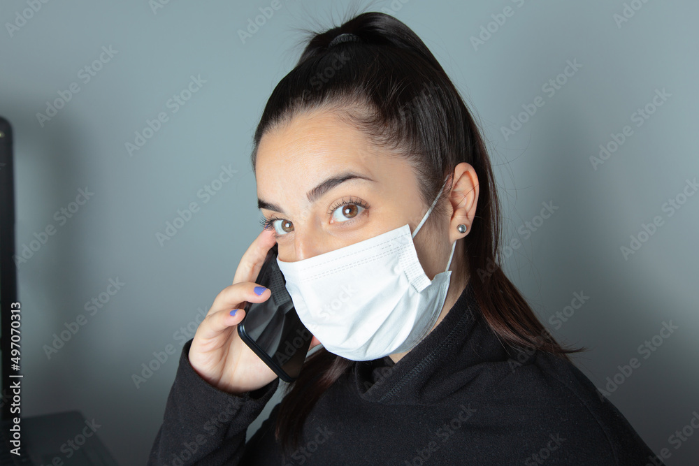 Mujer con mascarilla atendiendo al teléfono. Chica hablando por teléfono. Empresaria cogiendo cita telefónica Mujer con mascarilla atendiendo al teléfono. Chica hablando por teléfono. Empresaria cogiendo cita telefónica