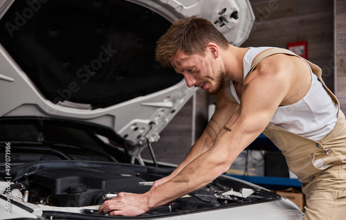 Close Up Shot of a Professional Mechanic Working on Vehicle in Car Service.