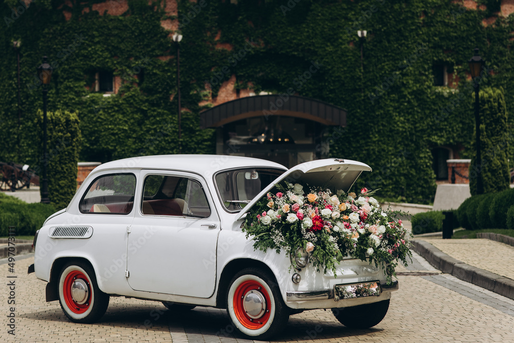 White retro car with flowers. Flowers delivery.