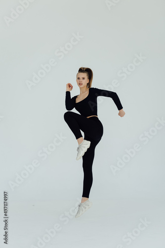 Portrait of a s fitness woman in headphones working out isolated over white background