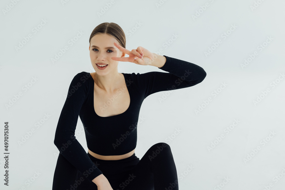 Young sport athletic woman, runner sitting on floor studio and smiling. Sportswoman resting during workout, laughing, enjoy training session jogging, white background
