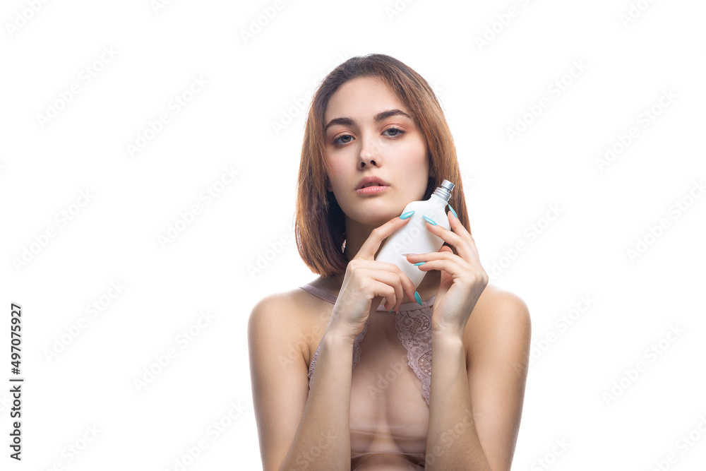 A beautiful sexy lady in an elegant nude bodysuit holds a bottle in her hands. Fashion beauty portrait of fashion model girl on isolated white background. A beautiful sexy lady in an elegant nude bodysuit holds a bottle in her hands. Fashion beauty portrait of fashion model girl on isolated white background.