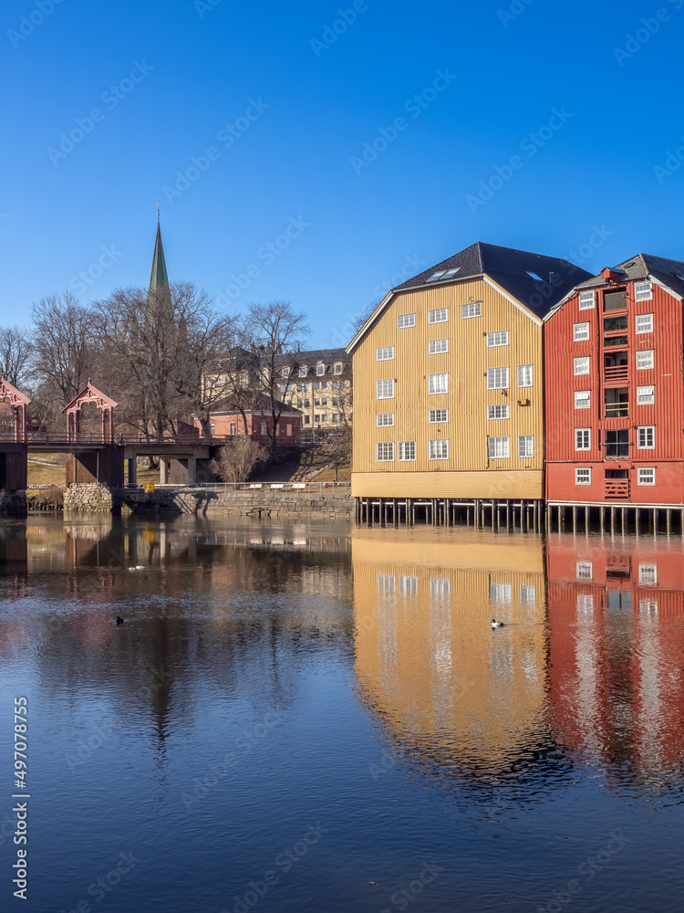 Obraz premium Scenes on the shores of the Nidelva river, with the old town bridge and the spire of the Nidaros Cathedral, Old town of Trondheim, Trøndelag, Norway