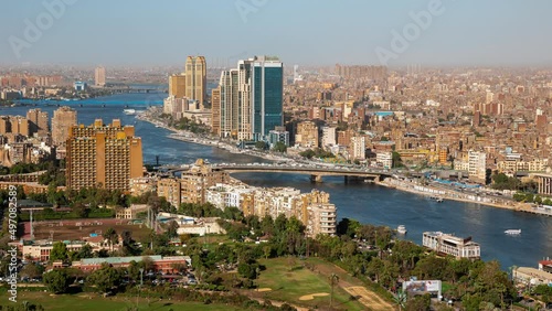 Top view of modern Cairo, river Nile, island Gezira. Timelapse. Daily life in capital of Egypt with buildings, trees, skyscrapers, cars, boats. Transport moving, ships sailing, people going