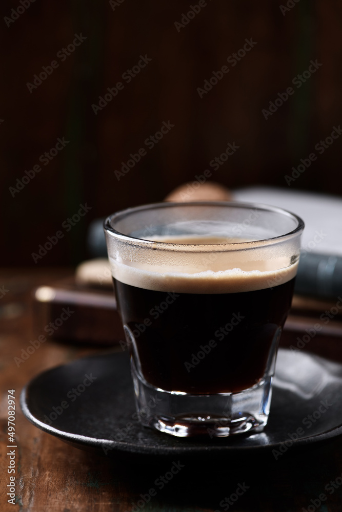 Coffee in glass cup on dark wooden background. Close up. Coffee in glass cup on dark wooden background. Close up.