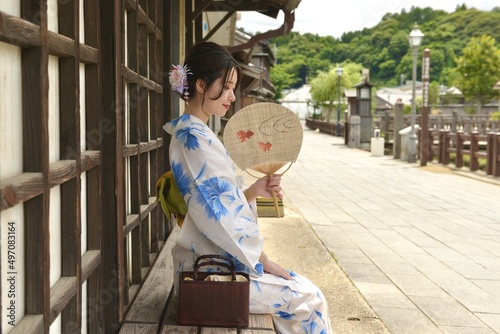 小江戸佐原の町並みで団扇を手に微笑む浴衣姿の若い女性	