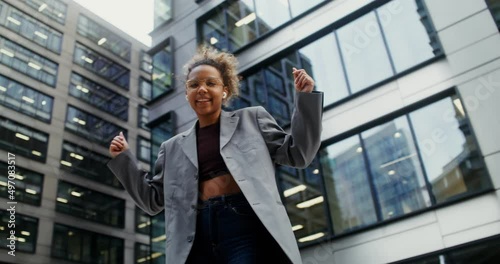 Wallpaper Mural A woman wearing headphones listens to music and dances outside office building Torontodigital.ca