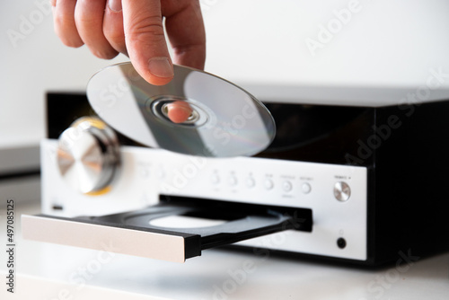 Hand inserting a cd disc to stereo system to listen music